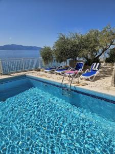 a swimming pool with lounge chairs and the water at Rooms Falcon in Brist