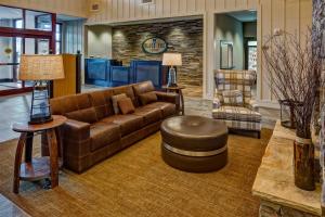 a living room with a brown couch and a stool at Black Fox Lodge Pigeon Forge, Tapestry Collection by Hilton in Pigeon Forge