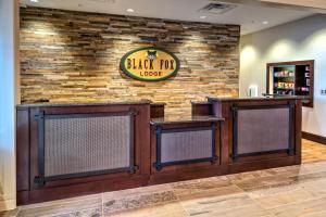 a black tie lodge lobby with a stone wall at Black Fox Lodge Pigeon Forge, Tapestry Collection by Hilton in Pigeon Forge