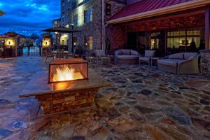 a stone patio with a fireplace on a building at Black Fox Lodge Pigeon Forge, Tapestry Collection by Hilton in Pigeon Forge