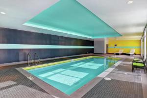 a swimming pool in a hotel room with a blue ceiling at Tru By Hilton Edmonton Windermere in Edmonton