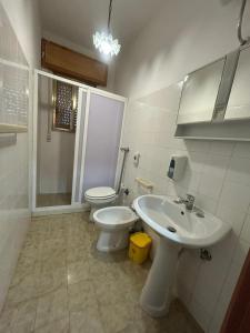 a white bathroom with a toilet and a sink at Capo Scalambri in Santa Croce Camerina +32 photos