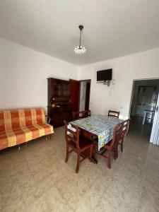 a living room with a table and chairs and a couch at Capo Scalambri in Santa Croce Camerina