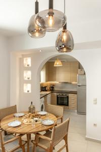 a kitchen with a wooden table with chairs and a dining room at Cozy Comfy Town House in Naxos Chora