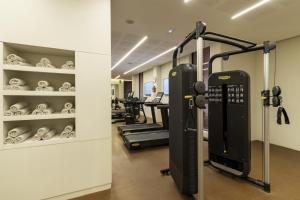 a gym with treadmills and machines in a room at Doubletree By Hilton Ben Guerir Hotel & Residences in Benguerir