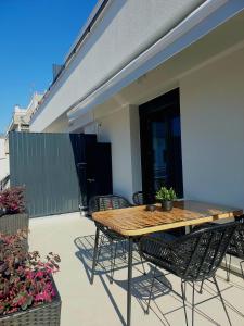 a wooden table and chairs on a patio at Ophelia's - Luxury Apartment in Volos