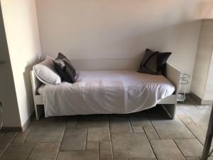 a bedroom with a bed with white sheets and pillows at Ancient village in Trieste