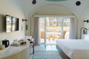 a hotel room with a bed and a view of a patio at Diamond Beach By Pearl Resort in Quseir +199 photos