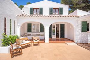an outdoor patio with a white house with green shutters at Villa Linda by 3VILLAS in Son Parc