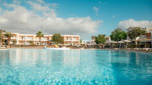 a swimming pool at a resort with chairs and umbrellas at BLUESEA Bahía de Lobos in Corralejo