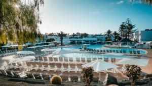 a resort with a pool and chairs and umbrellas at BLUESEA Bahía de Lobos in Corralejo