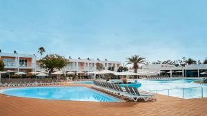 a pool with chairs and umbrellas in a resort at BLUESEA Bahía de Lobos in Corralejo +47 photos