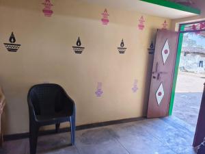 a black chair in a room with a wall with playing cards on it at Balendra Kumar in Tarahti +3 photos