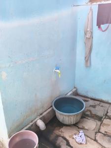 a bucket in a corner of a bathroom with a sink at Balendra Kumar in Tarahti