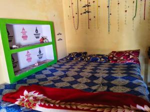 a bedroom with a bed and a green shelf at Balendra Kumar in Tarahti