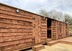 a wooden building with two clocks on the side at Glamping Tent - Bell Tent in Brackley