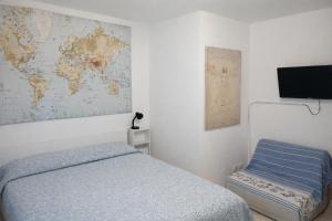 a bedroom with a bed and a map of the world at Affitta Camere di Berenice in Porto Azzurro