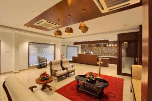 a living room with a couch and a table at Hotel Indraprastha Kozhencherry in Kozhancheri