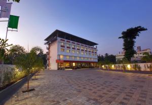 a large white building with a black roof at Hotel Indraprastha Kozhencherry in Kozhancheri
