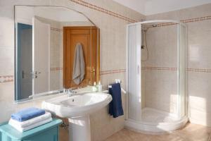 a white bathroom with a sink and a shower at Affitta Camere di Berenice in Porto Azzurro