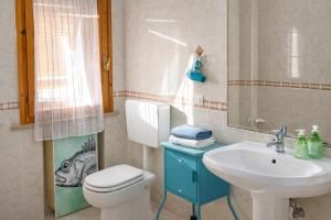 a bathroom with a white toilet and a sink at Affitta Camere di Berenice in Porto Azzurro +2 photos