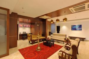 a living room with couches and a red rug at Hotel Indraprastha Kozhencherry in Kozhancheri