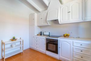 a white kitchen with white cabinets and a sink at Villa Linda by 3VILLAS in Son Parc