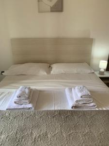 a bed with two towels on top of it at Don Michele Apartments in Gizzeria