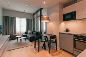 a living room with a table and chairs and a couch at Original Sokos Hotel Seurahuone Savonlinna in Savonlinna