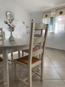 a dining room table with a chair and a vase of flowers at Don Michele Apartments in Gizzeria +80 photos