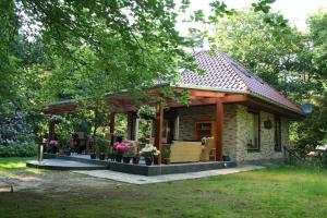 une petite maison avec un pavillon dans une cour dans l'établissement Landhuis "Op de Heugte", à Norg