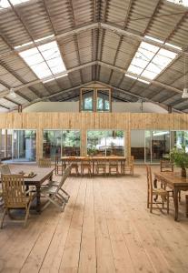 a large room with wooden tables and benches at Hangar Project in Saint-Michel-Escalus