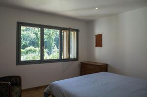 a bedroom with a bed and a window at Hangar Project in Saint-Michel-Escalus