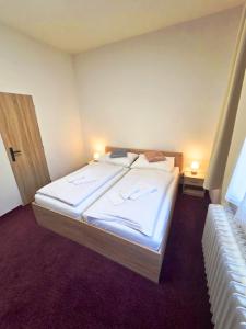 a bedroom with a large bed with white sheets at Hotel Incognito in Jáchymov +25 photos