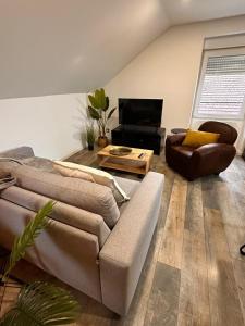 a living room with a couch and a table at Logement Pirate themed suite with parking in Vesoul