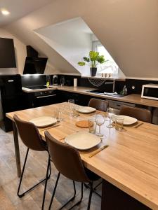 a large wooden table with chairs and a kitchen at Logement Pirate themed suite with parking in Vesoul