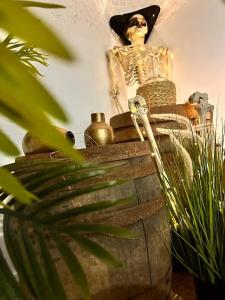 a statue of a skeleton sitting on top of a vase at Logement Pirate themed suite with parking in Vesoul