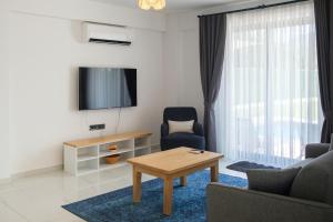 a living room with a couch and a table and a tv at Holiday Villa Lena in Köyceğiz