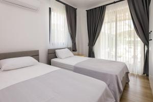 a bedroom with two beds and a window at Holiday Villa Lena in Köyceğiz +70 photos