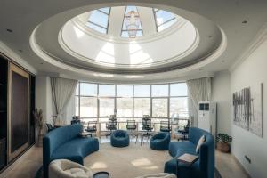 a living room with blue chairs and a large window at Full Moon Guesthouse in Dubai