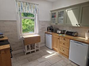 a kitchen with green cabinets and a window in it at Airlie Gardens in Brodick