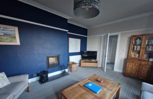 a living room with a couch and a coffee table at Airlie Gardens in Brodick