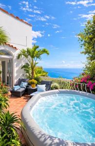 a pool on a patio with the ocean in the background at Villa Navarra in Praiano