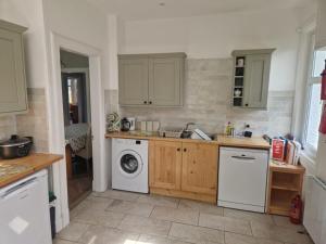 a kitchen with a washing machine and a washer at Airlie Gardens in Brodick +4 photos
