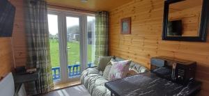 a living room with a couch and a large window at Mardi Gras, Upwell in Upwell