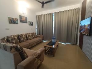 a living room with a couch and a tv at 1 bhk apartment ruby residency in Canacona