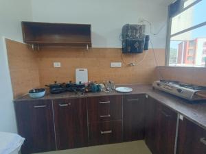 a kitchen with wooden cabinets and a sink and a window at 1 bhk apartment ruby residency in Canacona +5 photos