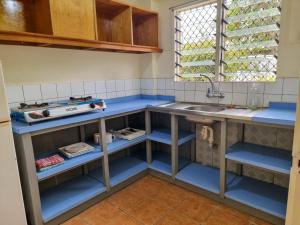 a kitchen with blue shelves and a sink at Panatina Hilltop Downstairs Unit in Honiara