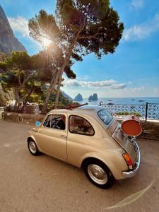 a small car parked on a road near the ocean at Casa Rubina in Capri