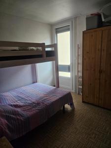 a bedroom with a bed and bunk beds in it at bord de mer in Leucate-Plage